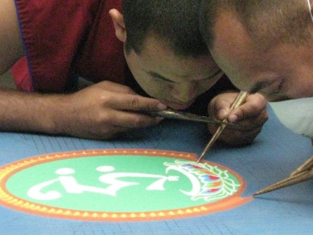 Gaden Shartse monks using chakpurs and colored sands to make a mandala at Seattle Asian Art Museum in collaboration with Dechenling