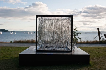 For her second installation at the Seattle Art Museum’s Olympic Sculpture Park, artist Carolina Silva covered the whole perimeter of the cube with Mylar strings hanging downwards from a mesh attached as a ceiling to the top of the cube. This installation is titled Within and engages the idea of a labyrinth.