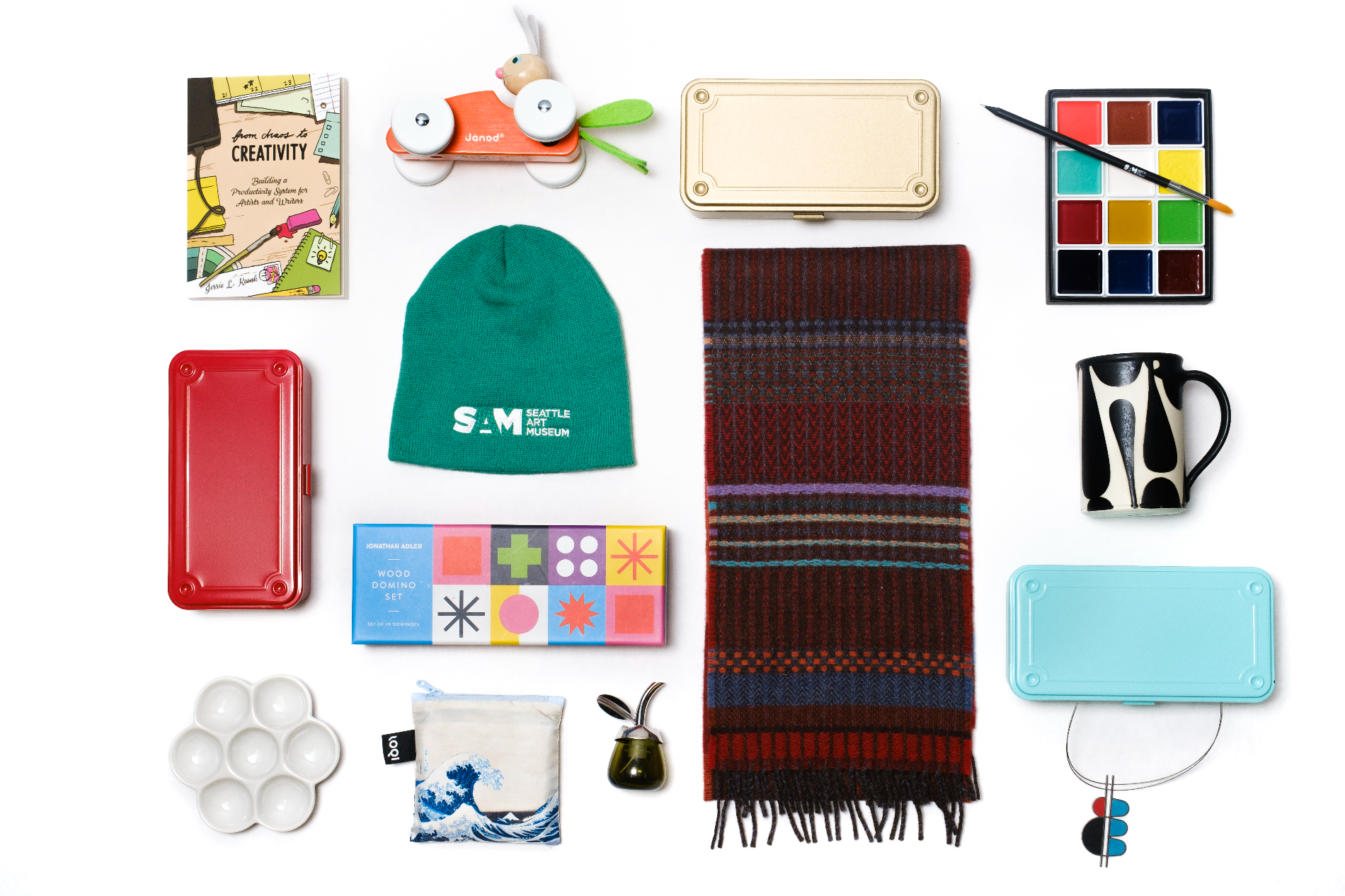 A holiday gift guide collage of objects against a white background, including a beanie, scarf, jewelry, toys, and art-making supplies